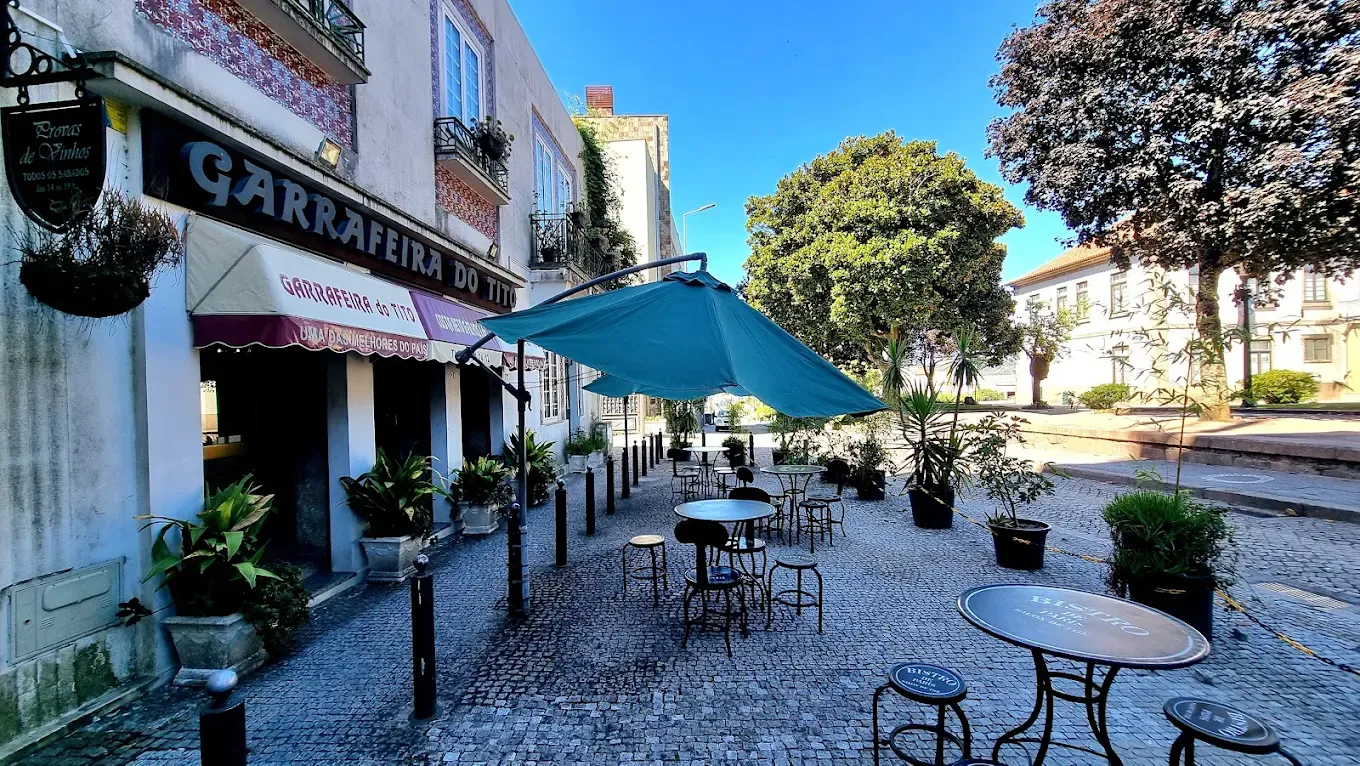 Esplanada da Garrafeira do Tito na praça, com chapéu-de-sol