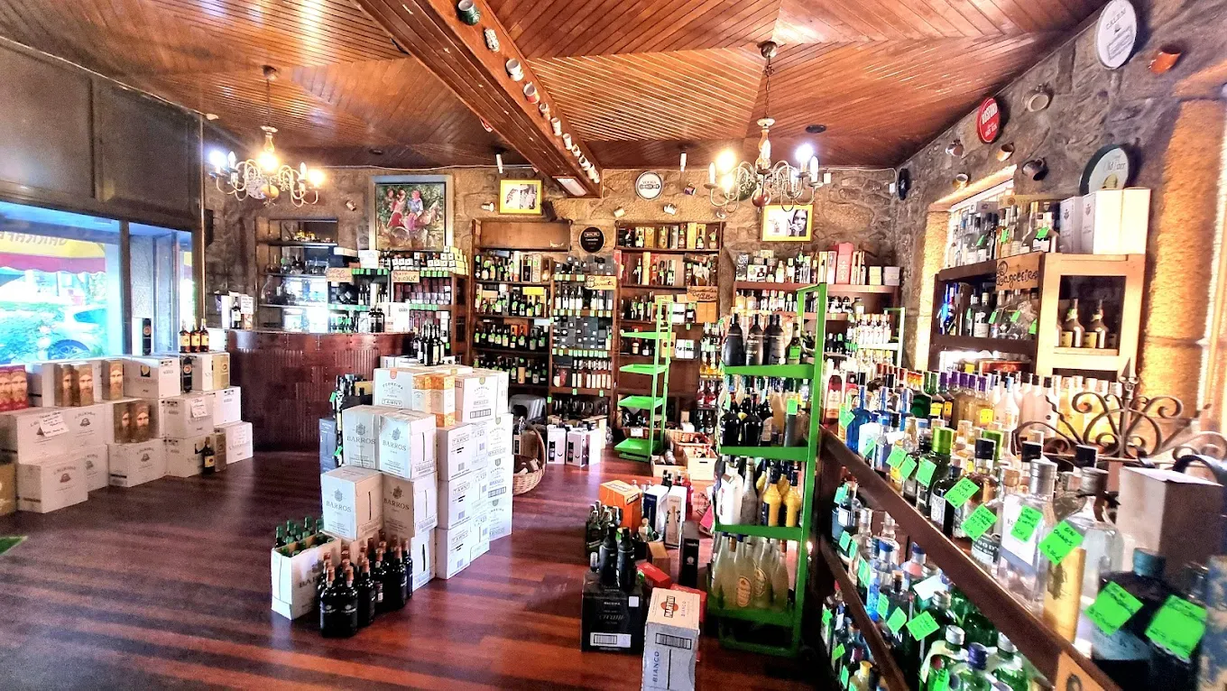 Interior da Garrafeira do Tito com prateleiras de vinhos e espirituosas